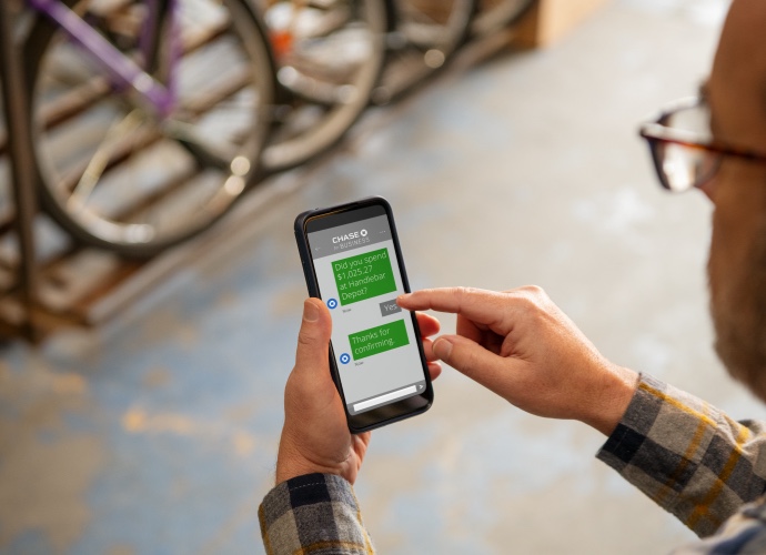 Bike shop owner messages on smartphone