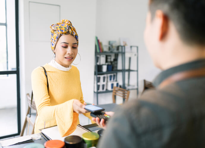A woman pays using contactless technology at a store