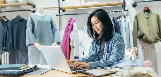 Woman working on a laptop in a clothing store