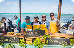 Chefs posing with their dishes alongside the beach during the famous Rum Point Beach Bash