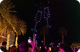 Marriott Bonvoy Cardmembers look up at drone fireworks the shape of champagne glasses toasting in the night sky