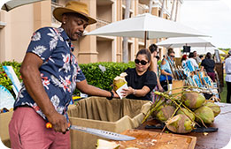A chef hands a freshly cut coconut to a Marriott Bonvoy Cardmember