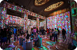 Colorful art is projected onto the walls at the Hall des Lumières Immersive Art & Dining Experience
