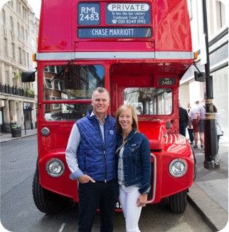 Cardmembers in London stand in front of a red double decker bus