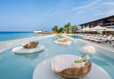 Luxurious oceanside pools and chaise longues at The Westin Maldives Miriandhoo Resort