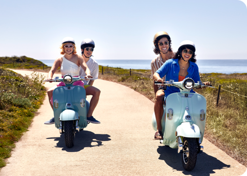 Two couples riding on Vespas