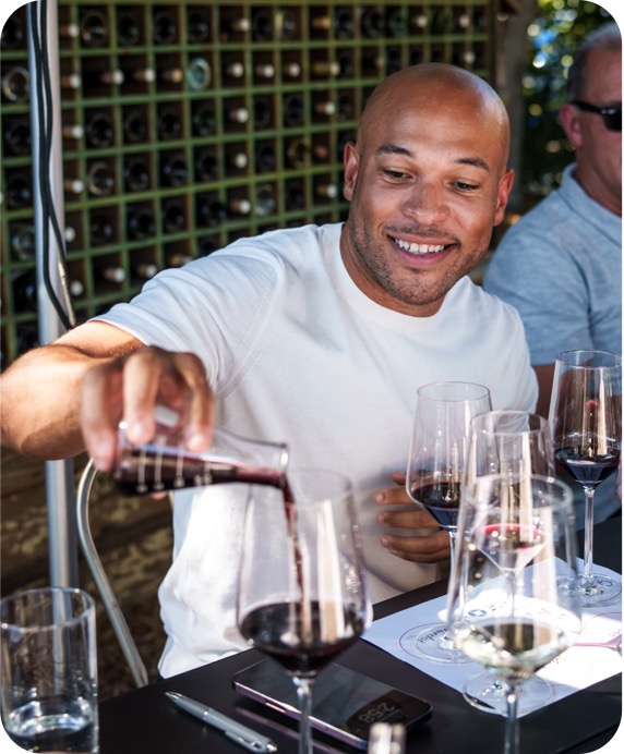 a cardmember pours wine into his glass
