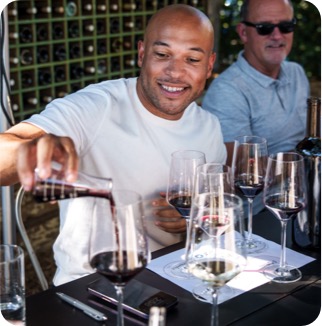 a cardmember pours wine into his glass