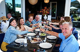 A group of Marriott Bonvoy Cardmembers seated at a table share a toast