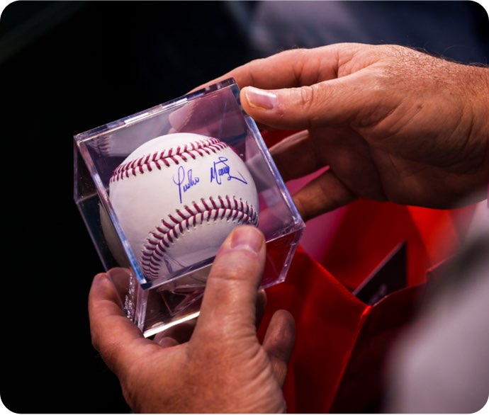 cardmember holds autographed baseball