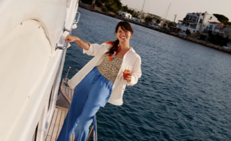 A woman stands on a boat deck overlooking the water