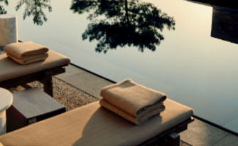 A close-up shot of folded towels sitting on a bench next to a pool