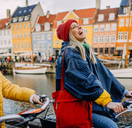 Mother and daughter biking along the river in a charming European town