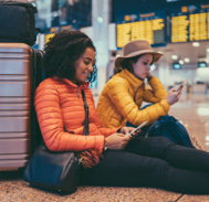 Two travelers wait at the gate by their luggage