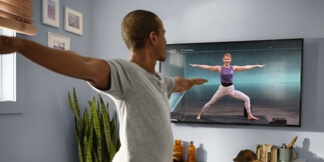 A man doing online yoga class in his living room
