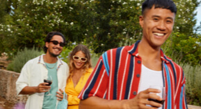 A group of friends enjoy wine at a backyard party