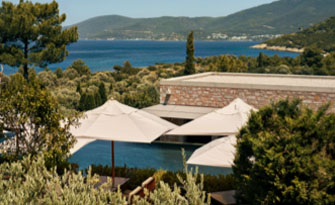 Luxury resort in Turkey with umbrellas, pool, greenery, and sea view.