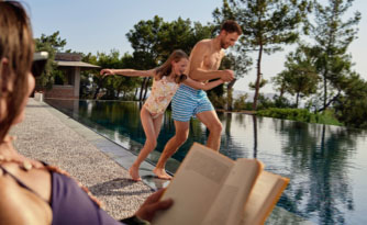 A father and daughter jump into water