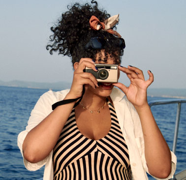 Woman on boat taking photo with disposable camera