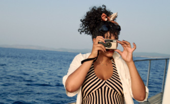 Woman on boat taking photo with disposable camera