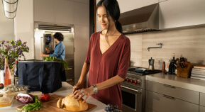 A mother and daughter prepare dinner in the kitchen