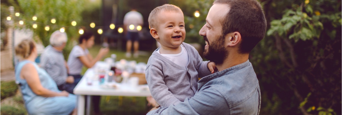 Smiling father and son at a backyard family barbecue.