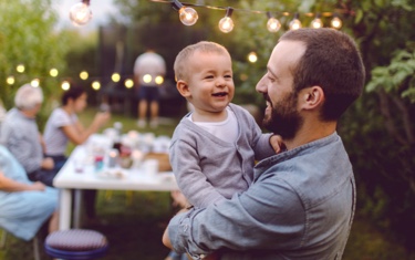 Smiling father and son at a backyard family barbecue.