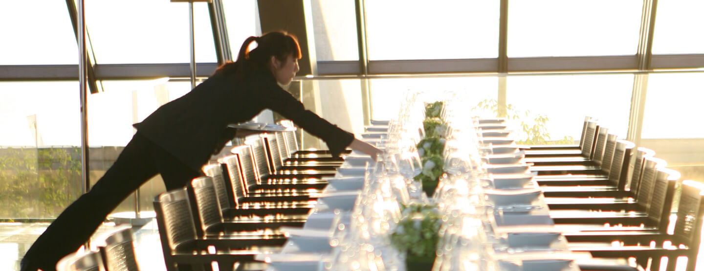 A server puts the finishing touches on a large dining table inside a Park Hyatt Beijing restaurant