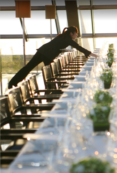 A server puts the finishing touches on a large dining table inside a Park Hyatt Beijing restaurant