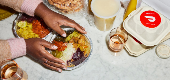 A woman sets her delivery order and drinks on her marble counter