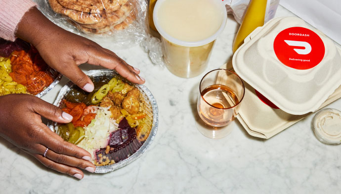 A woman sets her delivery order and drinks on her marble counter