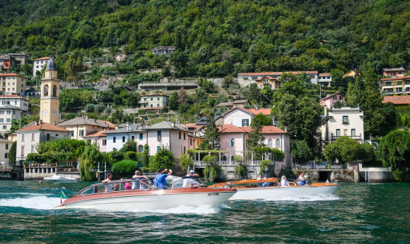 A man on a classic wooden motorboat on Lake Como