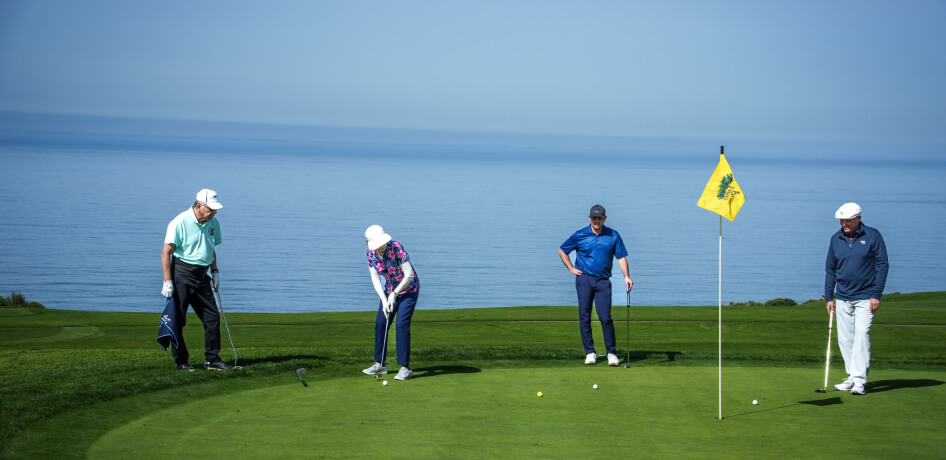 A group of cardmembers golfs at Torrey Pines, overlooking the Pacific Ocean.