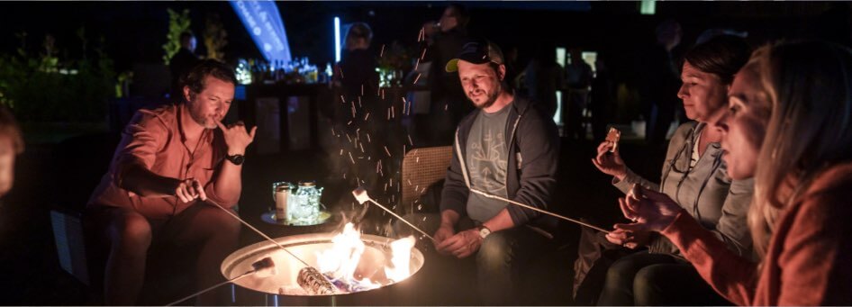 Guests roasting marshmallows over a fire pit