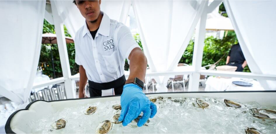 An employee putting oysters on ice