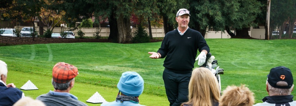 PGA pro David Duval speaks with guests on a golf course.