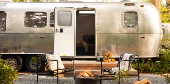 Two chairs set up in front of a luxury Airstream trailer