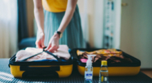 Woman neatly packing a suitcase
