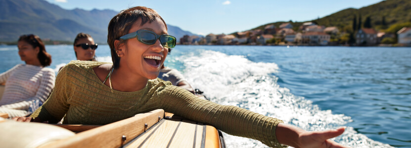 A smiling traveler and her friends riding a speedboat
