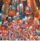 Hundreds of brightly lit multicolored lanterns hanging from a ceiling