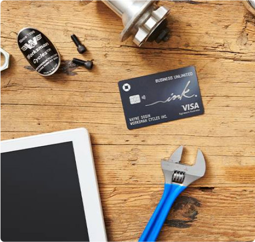 Tools and a tablet surrounding a Ink Business Unlimited card on a wooden table