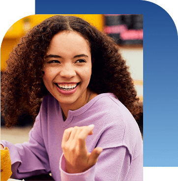 Girl holding taco and smiling