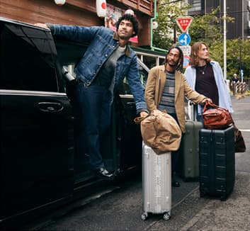 Three men leaving a van with suitcases