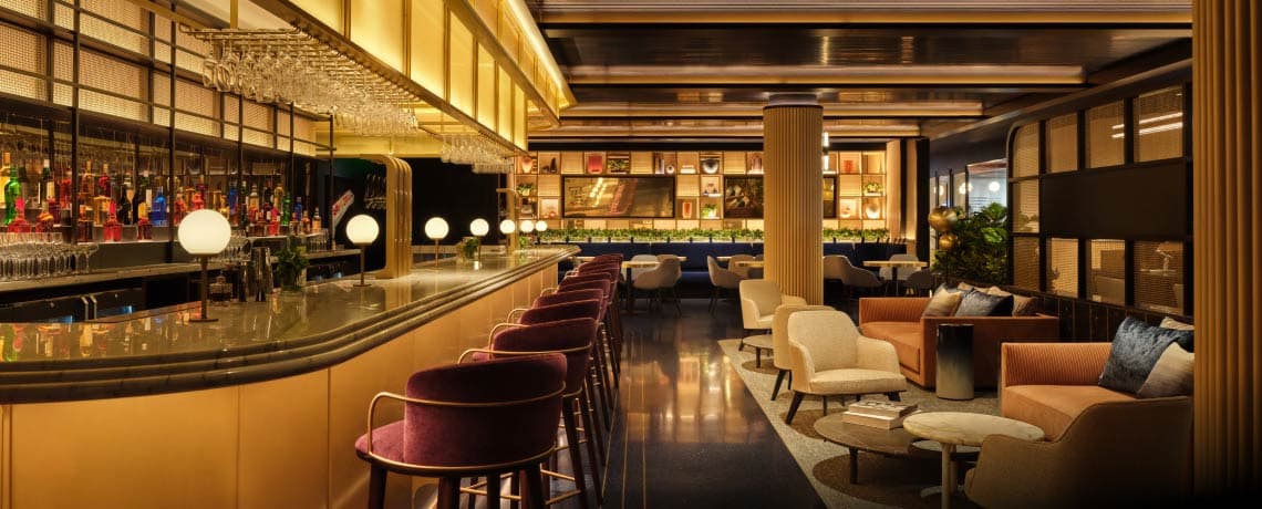 Sapphire Lounge at Philadelphia International Airport with a long bar counter, high chairs, elegant lighting, and plush seating areas.