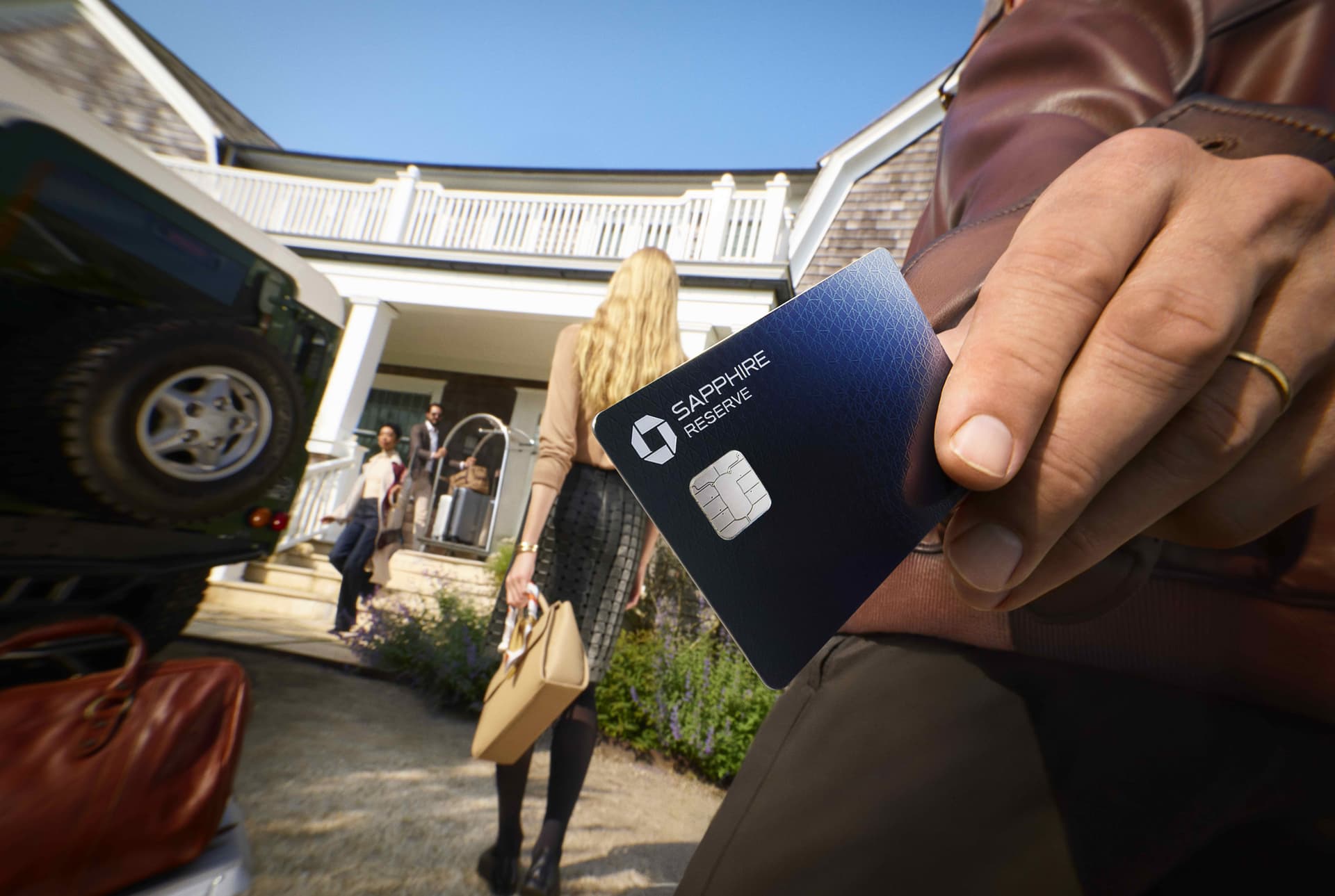 Person holding Sapphire card outside a hotel.
