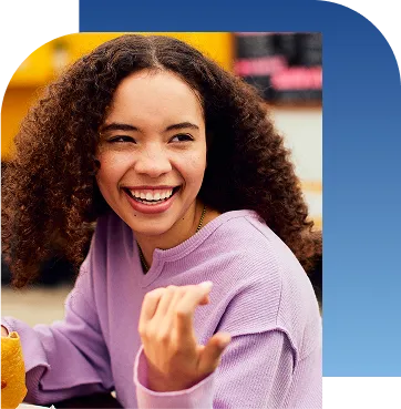 Girl holding taco and smiling