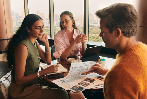 Three friends working together at a table