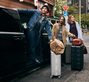 Three men leaving a van with suitcases