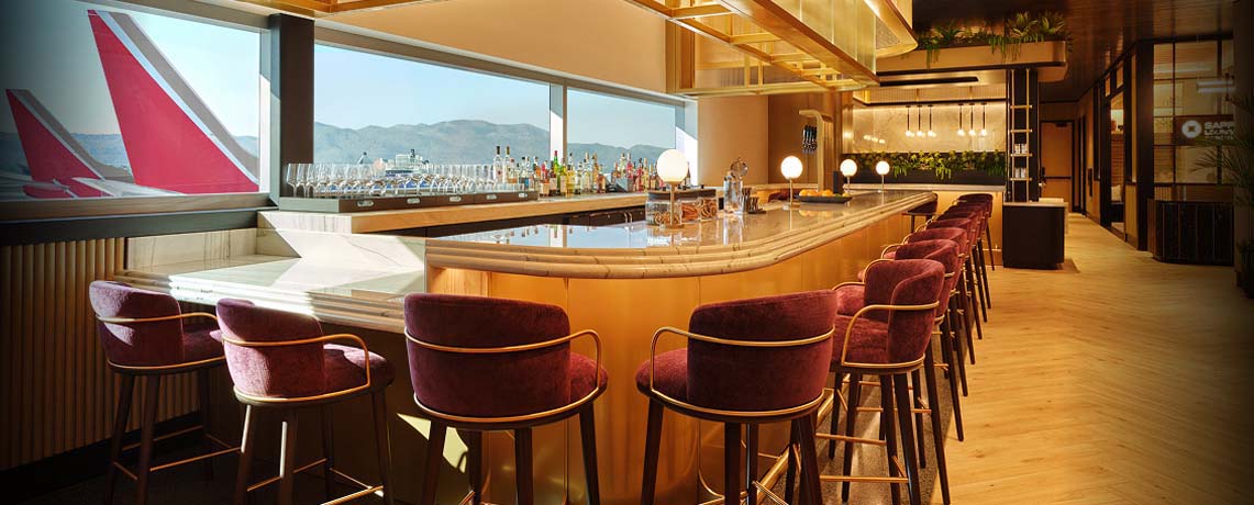 Sapphire Lounge at Phoenix Sky Harbor International Airport with a curved bar counter, purple stools, and large windows with runway views.