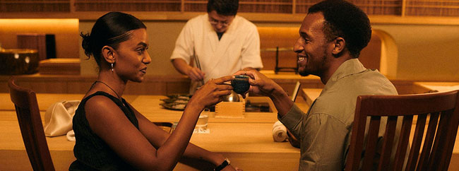 Two people toasting with drinks at a dining table in a Japanese restaurant.